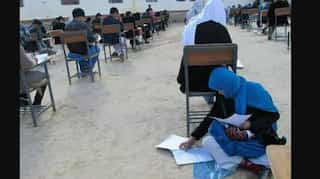 Heartwarming picture shows Afghan woman nursing her baby while writing exam