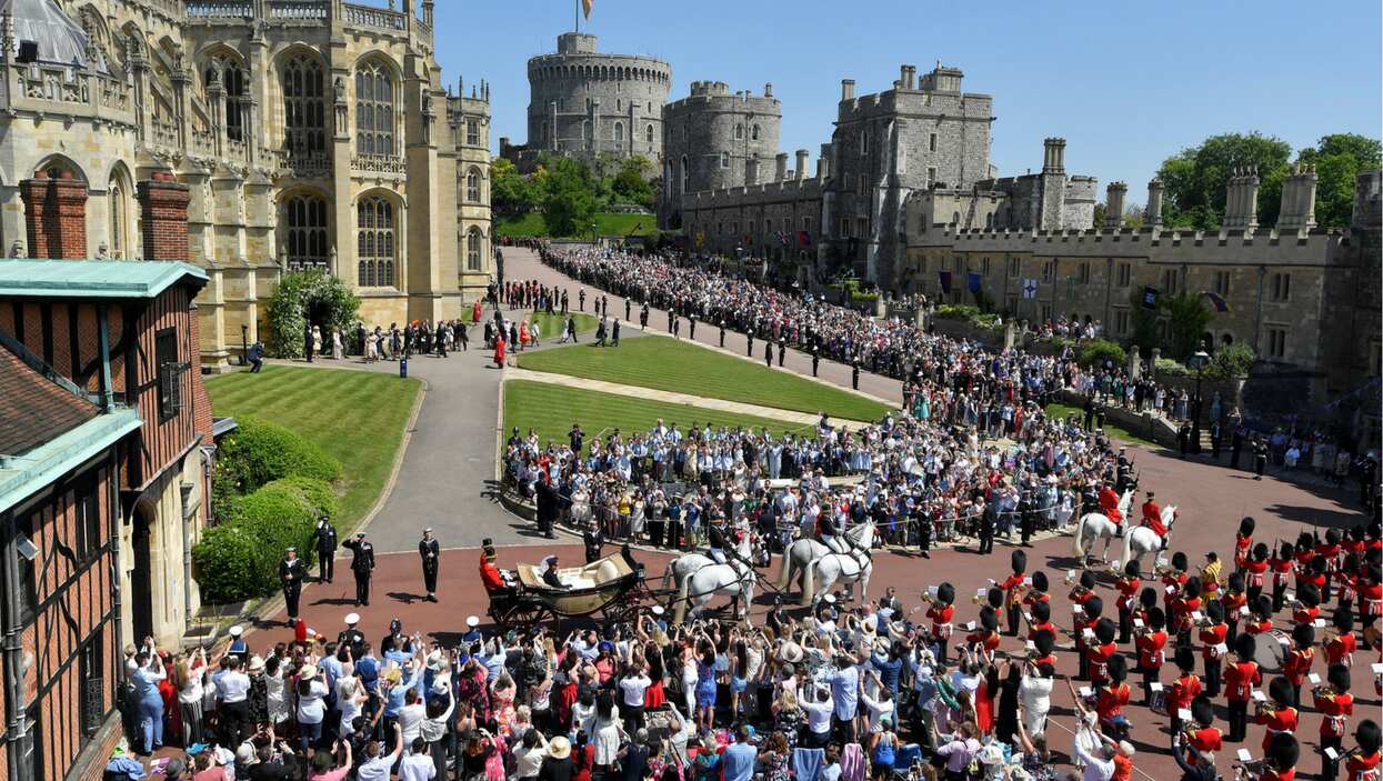 Prince Harry and his wife Meghan ride a horse-drawn carriage