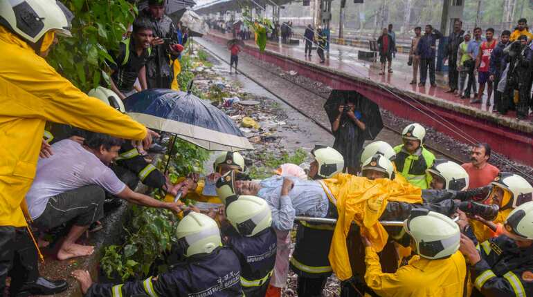 Rescue workers carry an injured man for treatments after a foot-overbridge collapsed