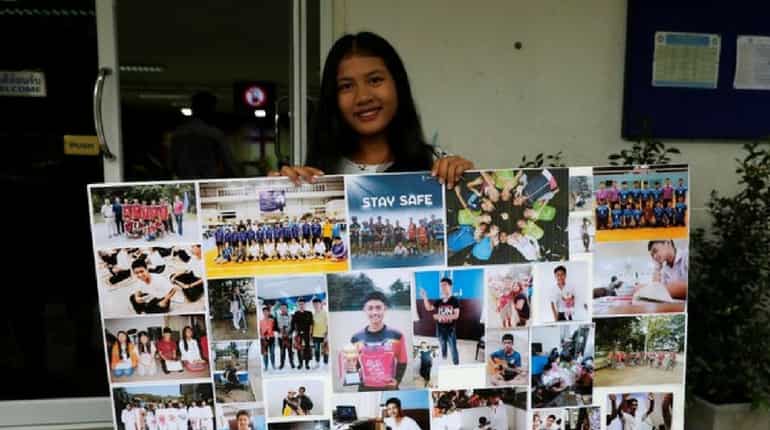 A girl shows a collage of pictures of trapped boys