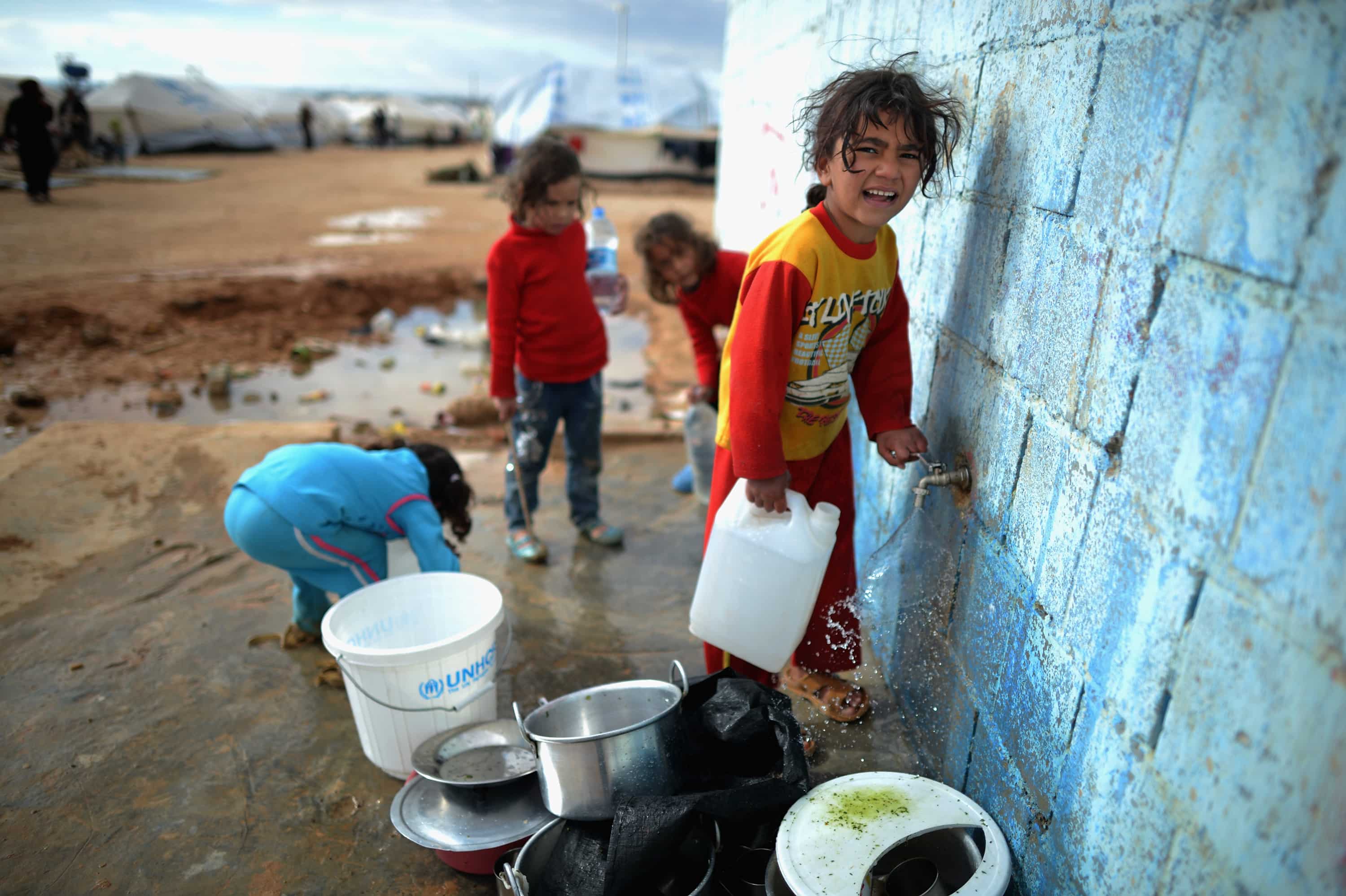 Syrian children gather water in the Za?atari refugee camp on January 29, 2013 in Mafraq, Jordan.