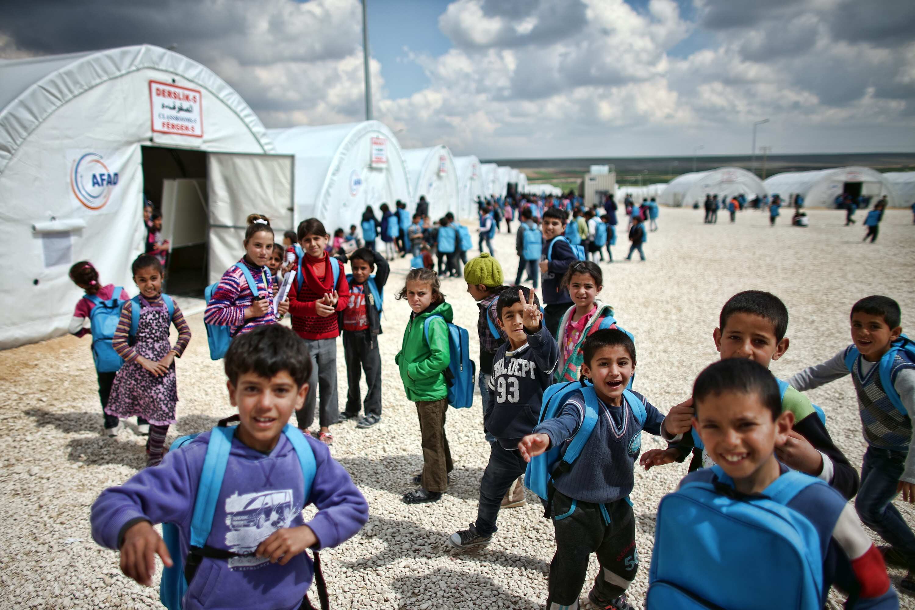 Syrian children delight in a 'camera moment' as they wait to attend lessons at a school in Suruc refugee camp on March 25, 2015 in Suruc, Turkey. The camp is the largest of its kind in Turkey with a p