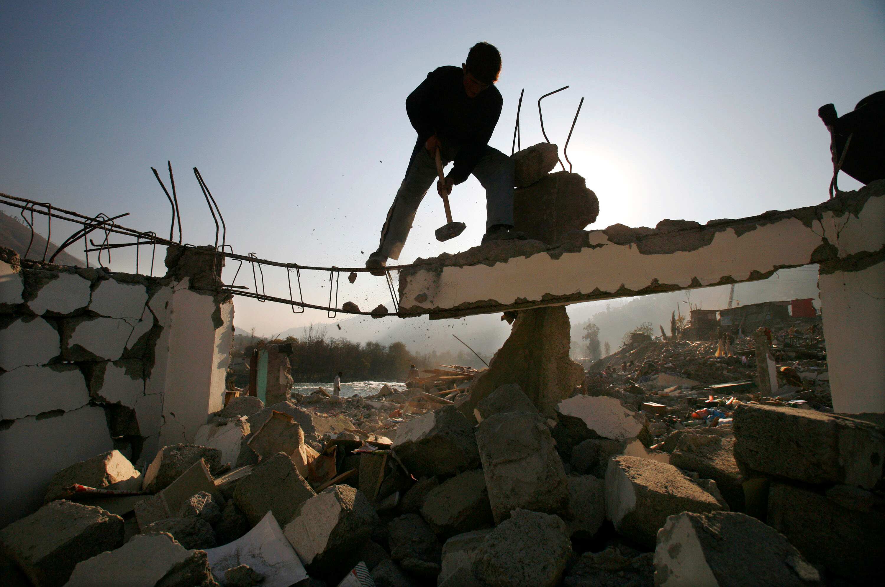 An earthquake survivor hammers at the ruins on December 17, 2005 in the town of Balakot, Pakistan. Survivors cleared debris themselves as the lack of equipment hindered rescue and clearing operations.