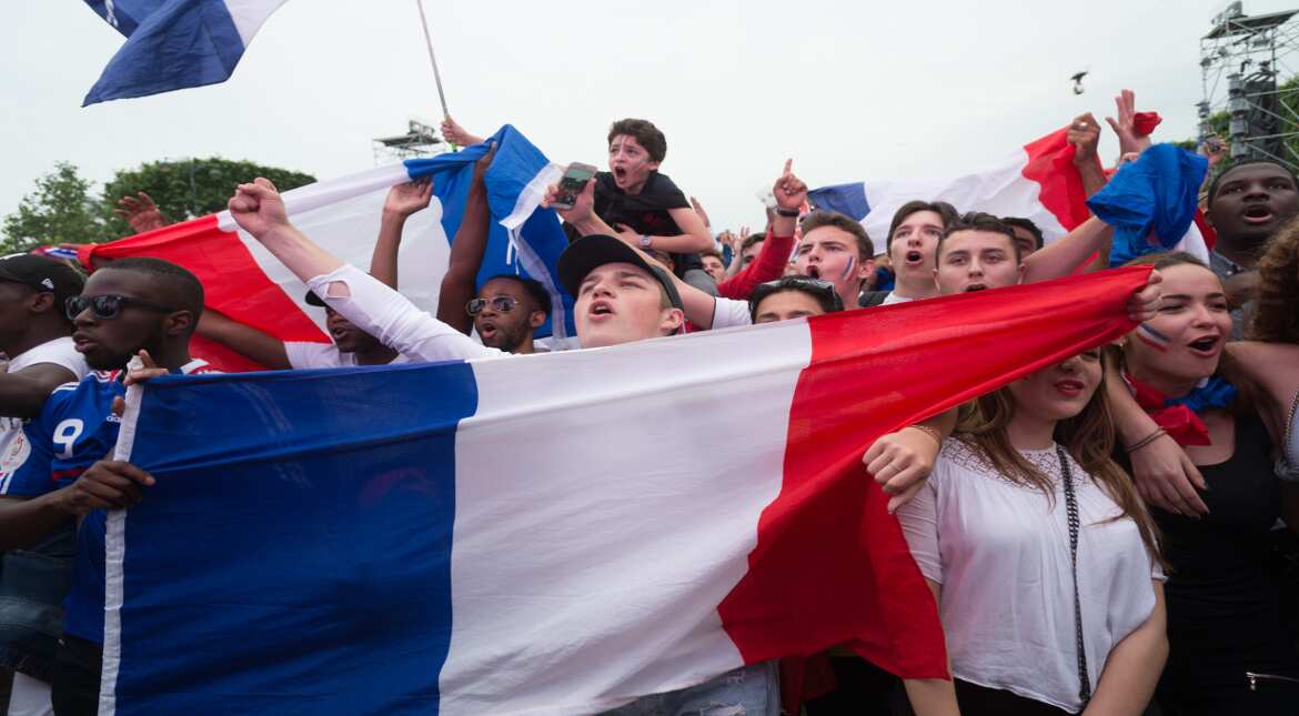 Football fans wave a French national flag in the Eiffel Tower fan zone as the French capital prepares to host the 2016 UEFA European Football Championship, June 10, 2016 in Paris, France. (Photo by T
