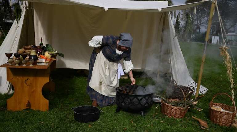 Denise Fitzgerald playing a tavern owner gets a fire ready to cook pottage