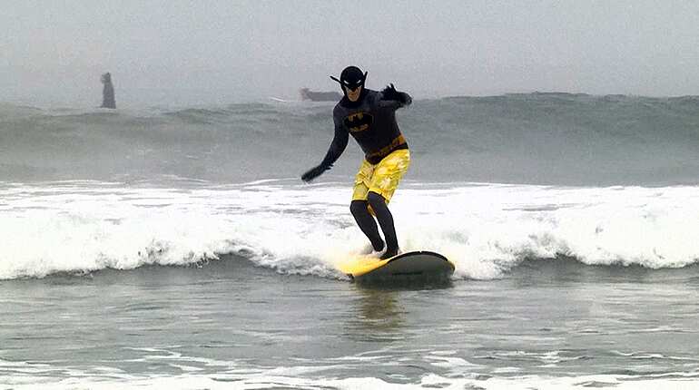 Surfers hit Newport Beach waves in Halloween costumes