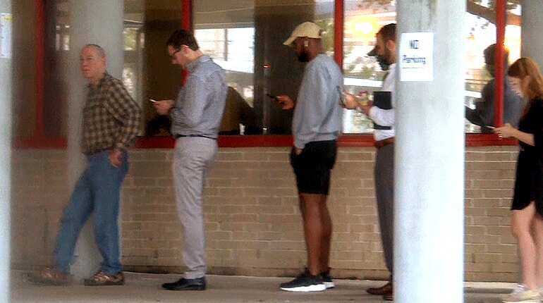 People stand in line waiting to cast their ballots in Houston