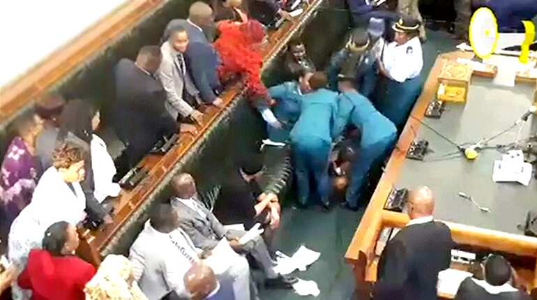 Zimbabwe opposition MPs removed from parliament after refusing to stand when president entered