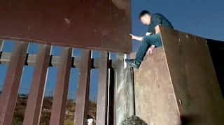 Watch: Migrants jump US-Mexico border fence at night
