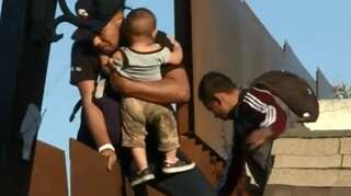 Father, baby detained after climbing Tijuana border fence