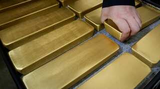 Gold hits two-week low as upbeat US data lifts dollar