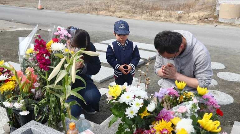 Family members pay tributes at a ceremony