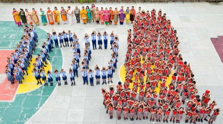 School students stand in shape of number '100'