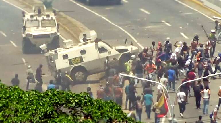 Venezuela National Guard armoured vehicle drives into protesters during opposition uprising