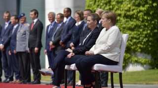 Merkel sits through anthems after shaking spells
