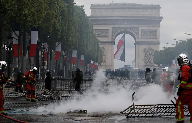 French police fire tear gas as protests follow Bastille Day parade