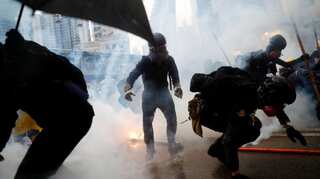 Hong Kong police briefly turn water cannon on protesters, fire tear gas