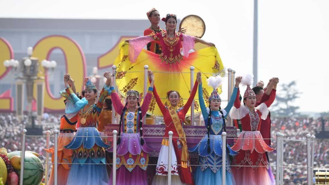 Performers stand on the Xinjiang region float
