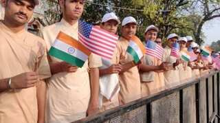 Students hold India-US flags to welcome US President Donald Trump in Ahmedabad