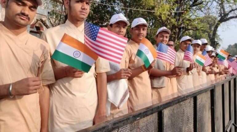 Students hold India-US flags to welcome US President Donald Trump in Ahmedabad