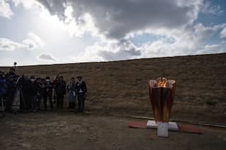 Olympic flame gets muted welcome in Japan as Games doubts grow