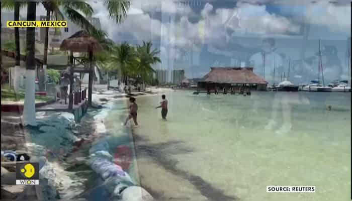 Tourists dip their toes in water as top Mexican beach getaway reopens