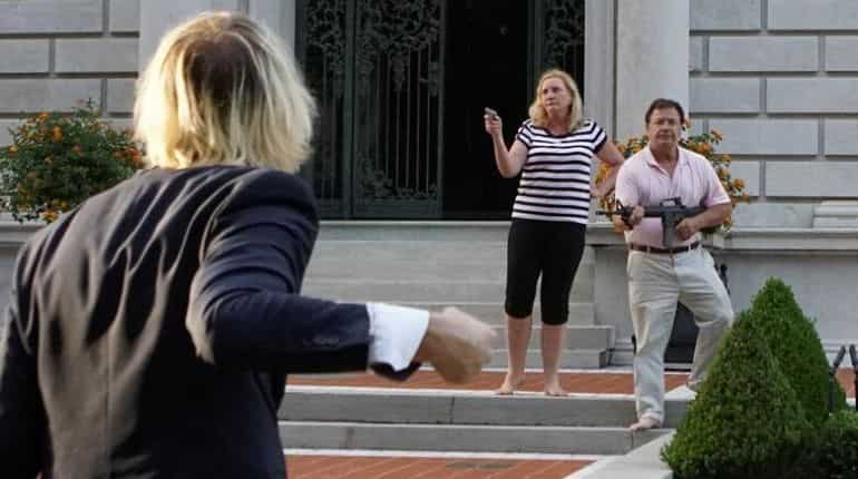 US couple draw guns on protesters passing their mansion
