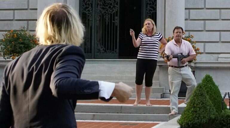 US couple draw guns on protesters passing their mansion