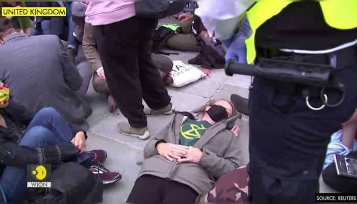 Climate activists glue themselves to street outside British parliament