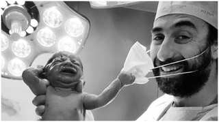 Viral photo of baby removing doctor's mask becomes an emblem of hope