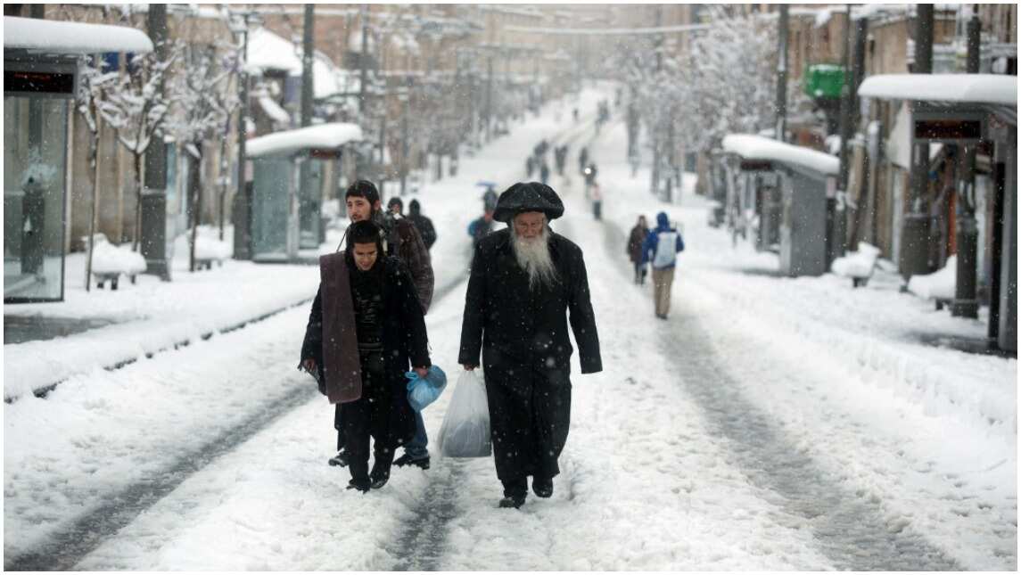 Residents trudge the snow-filled streets