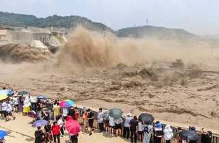 Chinese soldiers blast dam to divert floodwaters as record rains kill 25