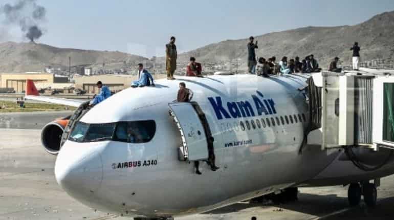 People climb atop a plane