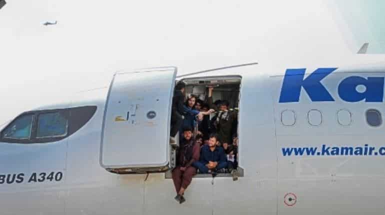 People sit by the door of a plane