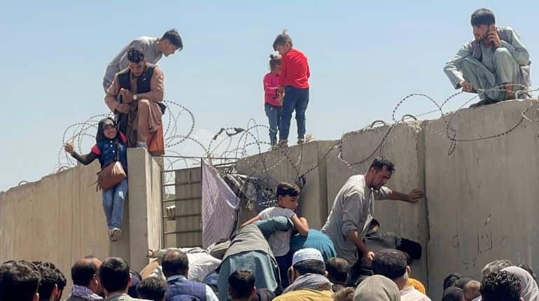 Man pulls a girl to get inside Kabul airport