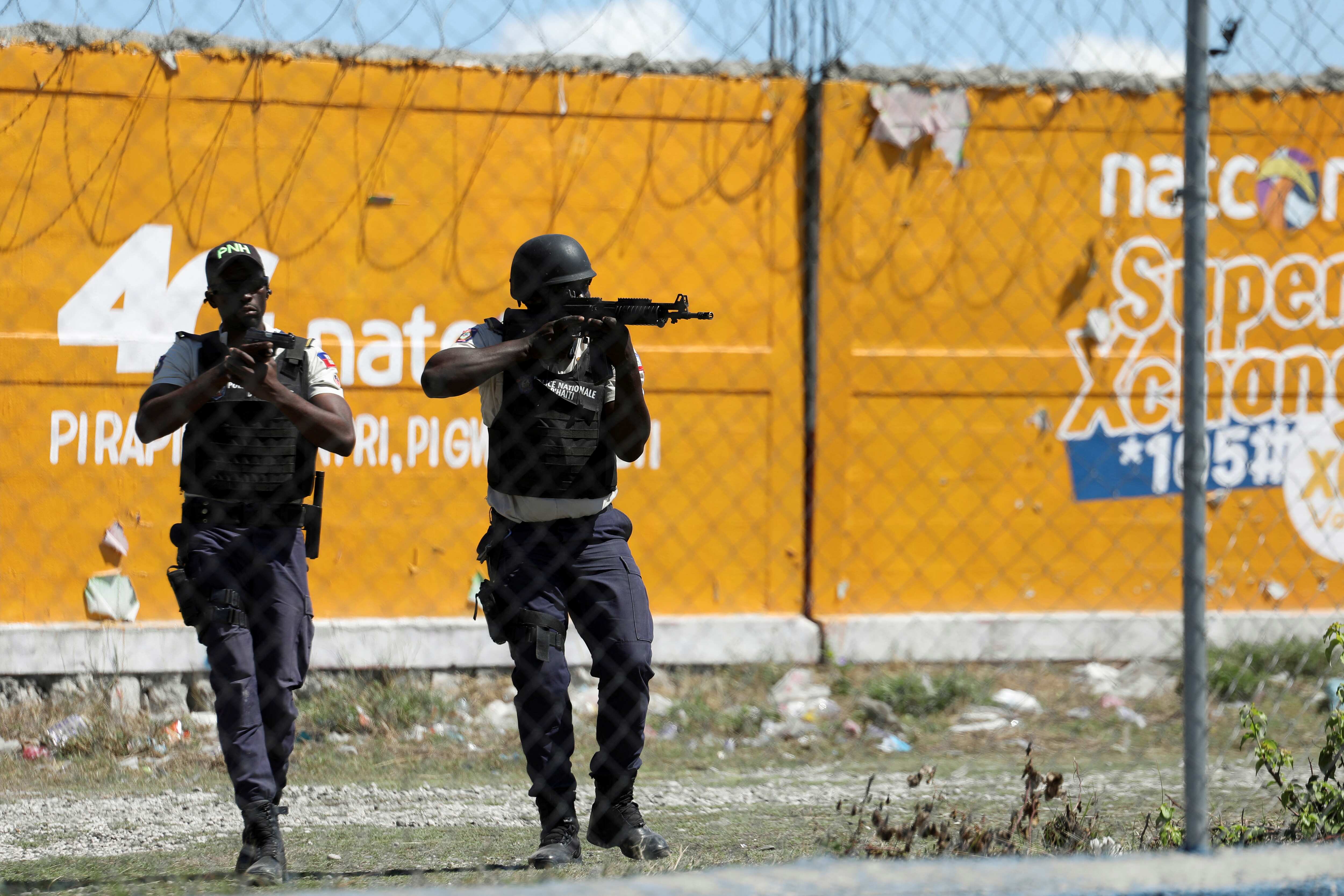 Police officers pointing weapons during protest