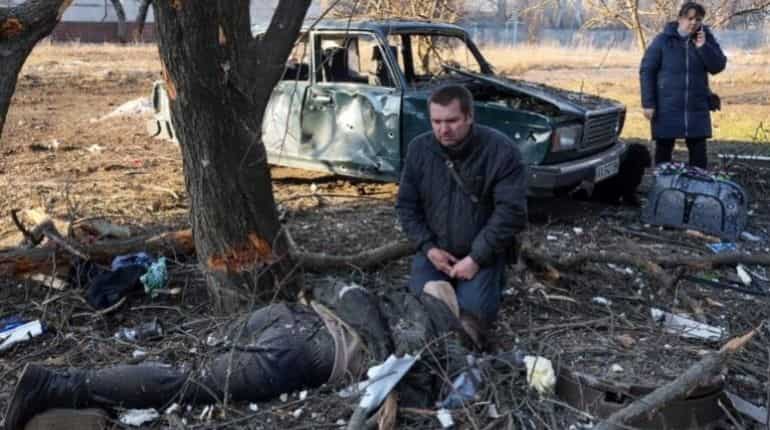 Picture shows a Ukrainian crying near body of man killed in Russian strike