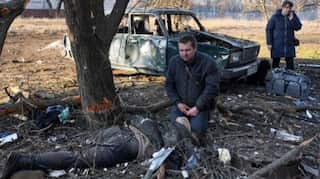 Picture shows a Ukrainian crying near body of man killed in Russian strike