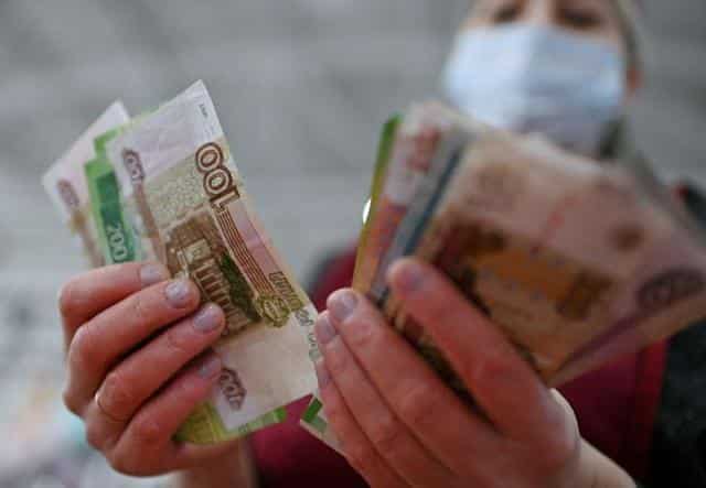 Russian currency tumbles to a record low as markets react to new economic sanctions