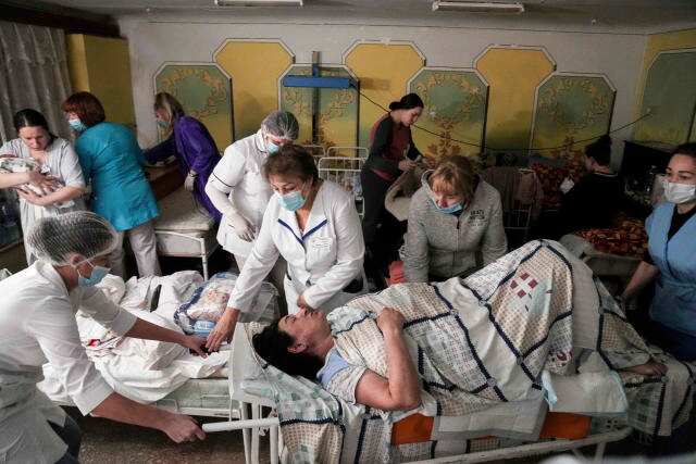 Hospitals move patients to basements as a 40-mile-long armed Russian convoy encircles Kyiv