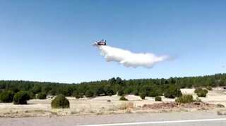 Plane drops water to combat fast-spreading wildfires in New Mexico
