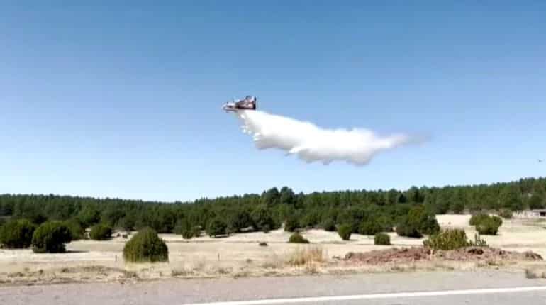 Plane drops water to combat fast-spreading wildfires in New Mexico