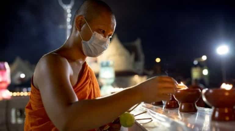A monk lits up a candle