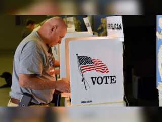 People cast their ballots in secured boxes as early voting for US midterm election begins