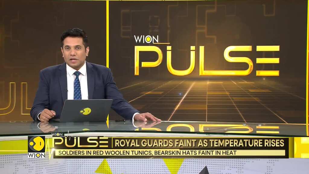 UK: Royal soldiers in red woolen tunics, bearskin hats faint in heat