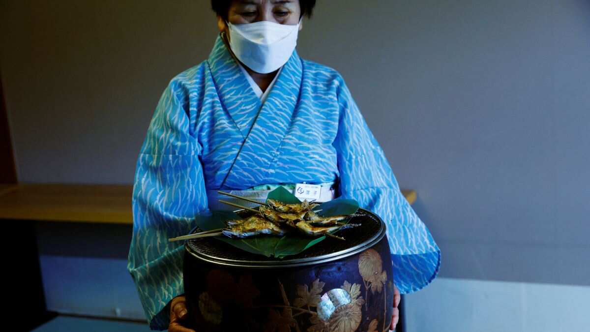 Waitress serving fish caught by cormorant fishing