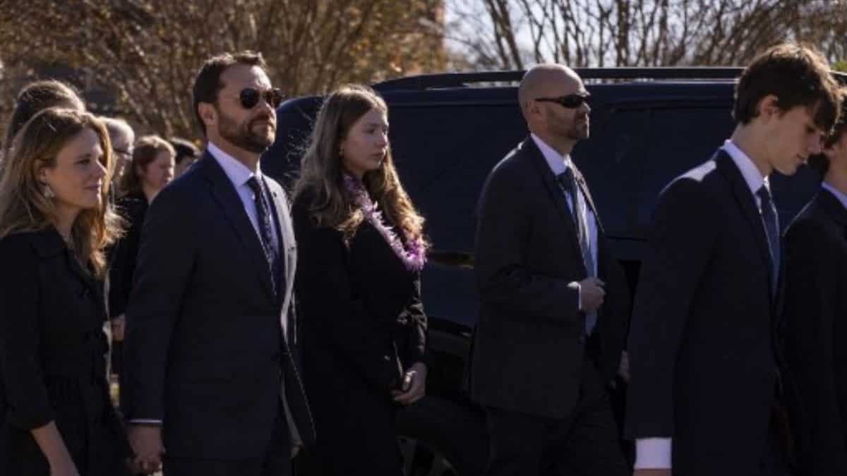 Family members follow procession following a funeral service