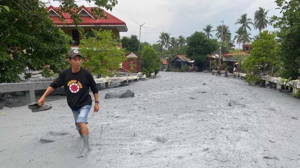 Heavy rain washes cold lava and debris through Philippines village - see pics