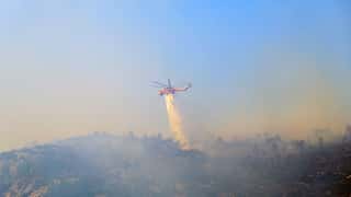 Dozens of firefighters in Greece battle to stop wildfire ignited north of Athens