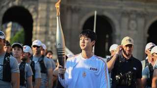 BTS member Jin carries the iconic torch through Paris streets ahead of Olympics 2024